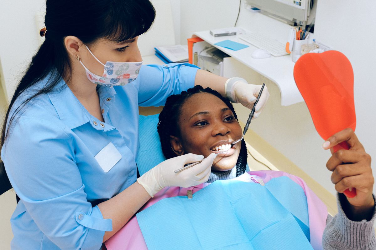 Odontóloga mostrando su nueva sonrisa a una paciente en Integro Dental Clinic
